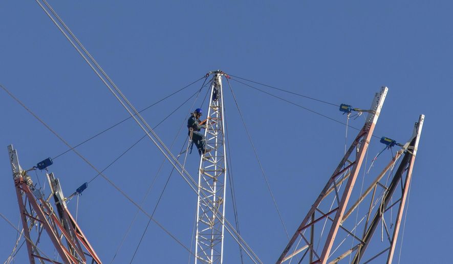 A technician works to continue dismantling Tower 412 and replace it with a new tower, in the Litoral corredor near the town of Zarate, on the border of Buenos Aires and Entre Rios provinces, Argentina, Wednesday, June 19, 2019. Located in the Parana River, Tower 412 hasn't been operational since April while workers were building a new tower to replace it and a bypass system had been set up to handle the current. Argentina's government suggested the origin of Sunday's blackout may stem from this corredor, and hopes to give a detailed explanation of events in twelve days time once all the technical elements have been analyzed. (AP Photo/Tomas F. Cuesta)
