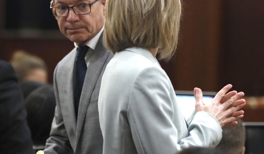 Andre Jackson's defense attorney Jerome Godinich looks back at prosecutor Tiffany Duprie as they discuss Jackson's case in the Harris County Criminal Courts, Wednesday, June 19, 2019, in Houston. Jackson is charged with the 2016 murder of 11-year-old Josue Flores. Newly tested DNA evidence led to the re-arrest of Jackson, authorities said Tuesday. (Karen Warren/Houston Chronicle via AP)