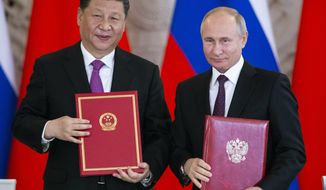 FILE - In this June 5, 2019 file photo, Russian President Vladimir Putin, right, and Chinese President Xi Jinping exchange documents during a signing ceremony following their talks in the Kremlin in Moscow, Russia. From nukes to huge food aid shipments to a shared skepticism about the United States, Chinese President Xi and North Korean leader Kim Jong Un will have a long list of topics to discuss when Xi heads north Thursday, June 20. (AP Photo/Alexander Zemlianichenko, Pool, File)
