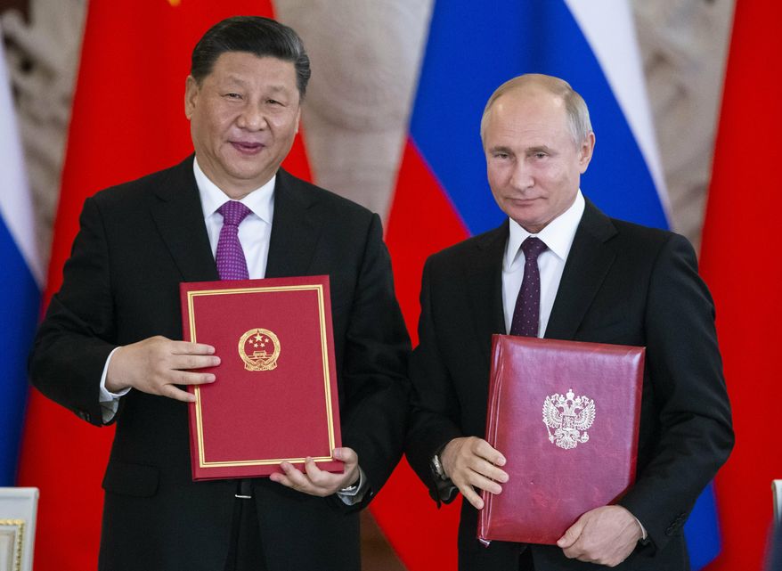 FILE - In this June 5, 2019 file photo, Russian President Vladimir Putin, right, and Chinese President Xi Jinping exchange documents during a signing ceremony following their talks in the Kremlin in Moscow, Russia. From nukes to huge food aid shipments to a shared skepticism about the United States, Chinese President Xi and North Korean leader Kim Jong Un will have a long list of topics to discuss when Xi heads north Thursday, June 20. (AP Photo/Alexander Zemlianichenko, Pool, File)