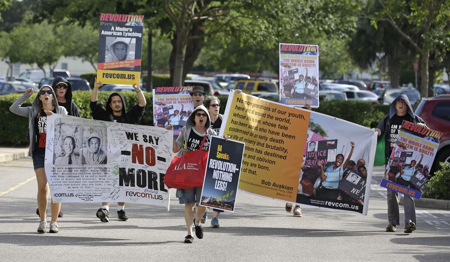 Members of the Revolutionary Communist Party, USA demonstrate outside the Seminole County Courthouse during the first day of trial for George Zimmerman, Monday, June 10, 2013, in Sanford, Fla. Zimmerman has been charged with second-degree murder for the 2012 shooting death of Trayvon Martin. (AP Photo/John Raoux)