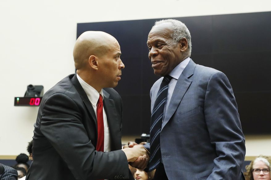 Democratic Presidential candidate Sen. Cory Booker, D-NJ, left, greets actor Danny Glover, before they testify about reparations for the descendants of slaves, during a hearing before the House Judiciary Subcommittee on the Constitution, Civil Rights and Civil Liberties, at the Capitol in Washington, Wednesday, June 19, 2019. (AP Photo/Pablo Martinez Monsivais)