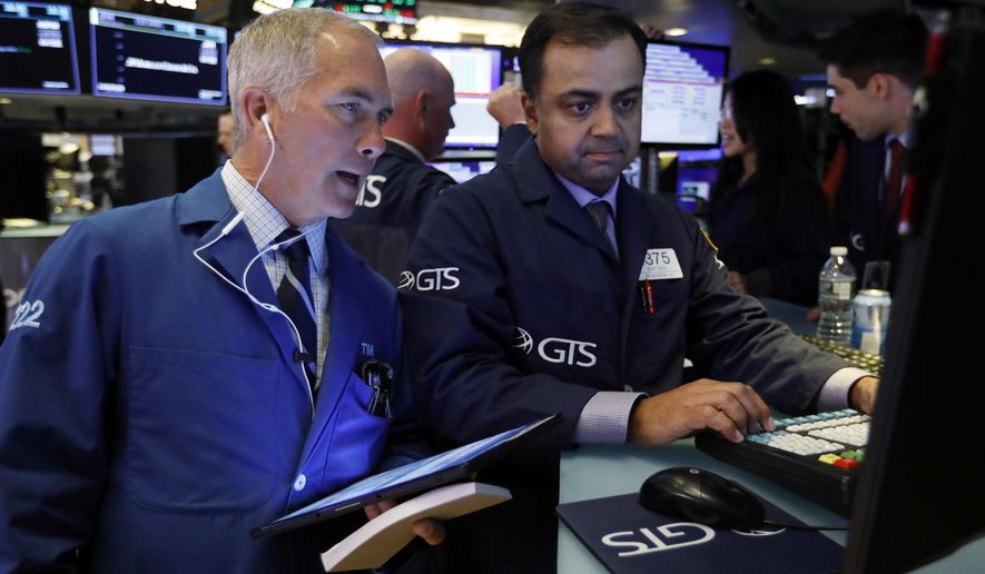 FILE - In this June 11, 2019, file photo trader Timothy Nick, left, and specialist Dilip Patel work on the floor of the New York Stock Exchange. The U.S. stock market opens at 9:30 a.m. EDT on Wednesday, June 19. (AP Photo/Richard Drew, File)