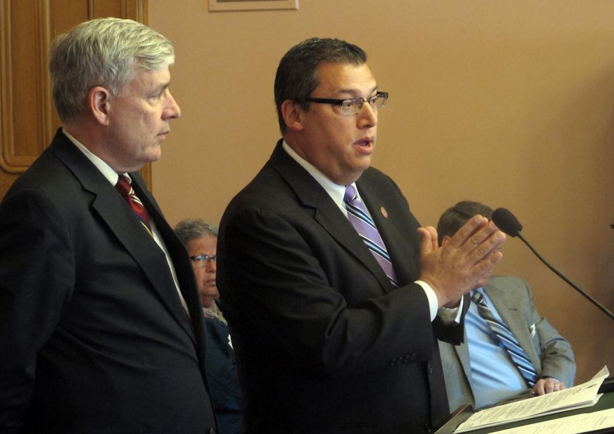 In this May 6, 2015 file photo, State Rep. Ron Hood, right, answers a question about his proposal to allow residents to carry a concealed weapon without first having to have a permit, with his co-sponsor, Rep. Tom Brinkman in Columbus, Ohio. An Ohio House committee has scheduled a vote on legislation allowing individuals to carry concealed weapons without having to receive training, undergo a background check or obtain a license. The House Federalism Committee meets Wednesday, June 19, 2019 on the bill sponsored by Hood and Brinkman, both Republicans. (AP Photo/Andrew Welsh-Huggins, File) **FILE**