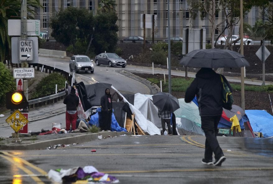 FILE - In this Jan. 17, 2019, file photo, pedestrians make their way along a rain soaked Hollywood Blvd., in Los Angeles. Mayor Eric Garcetti is paying a political price for the city&#39;s homeless crisis. An effort is underway to recall the two-term Democrat from office prompted by widespread complaints about homeless encampments throughout the city. Figures released earlier this month showed a 16% jump in LA&#39;s homeless population over the last year, pegging it at 36,300, the size of a small city. (AP Photo/Richard Vogel, File)