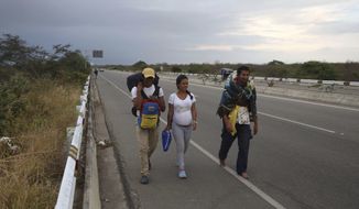 Venezuelan migrants walk on the Pan-American Highway, after crossing the Ecuadorian border into Tumbes, Peru, Friday, June, 14, 2019. Those fleeing the troubled South American nation filed more than one in five of all asylum requests made in 2018. That’s higher than requests made by people escaping Afghanistan and Syria. (AP Photo/Martin Mejia)