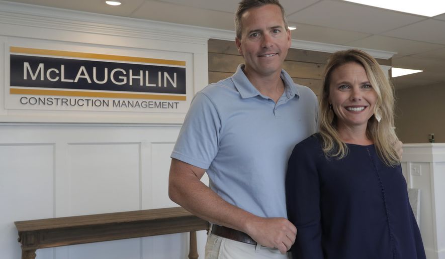 In this Wednesday, June 5, 2019, photo, Chris Carr, left, president of McLaughlin Construction Management, poses for a photo with his wife Kristy Carr in their office in Sea Isle City, N.J. When Kristy's father Jim McLaughlin died suddenly from a heart attack at age 64, his family assumed they would have to close his homebuilding business. But as McLaughlin’s son-in-law, Chris, started to wind down the Sea Isle City, New Jersey, company five years ago, he realized it was worth keeping open and that he, an accountant, should try to run it. (AP Photo/Julio Cortez)