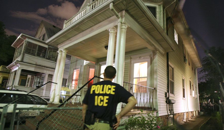 An agent from the Immigration and Customs Enforcement agency keeps watch at the side of a house while other agents from ICE are inside in search of a suspect during a sweep to capture illegal aliens with a criminal record in the Boston area, Tuesday, June 13, 2006, in the Brighton neighborhood of Boston. More than 2,100 illegal immigrants have been arrested since the nationwide raid began May 26. (AP Photo/Michael Dwyer)