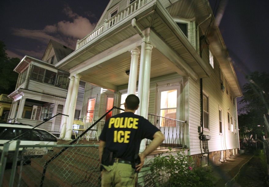 An agent from the Immigration and Customs Enforcement agency keeps watch at the side of a house while other agents from ICE are inside in search of a suspect during a sweep to capture illegal aliens with a criminal record in the Boston area, Tuesday, June 13, 2006, in the Brighton neighborhood of Boston. More than 2,100 illegal immigrants have been arrested since the nationwide raid began May 26. (AP Photo/Michael Dwyer)