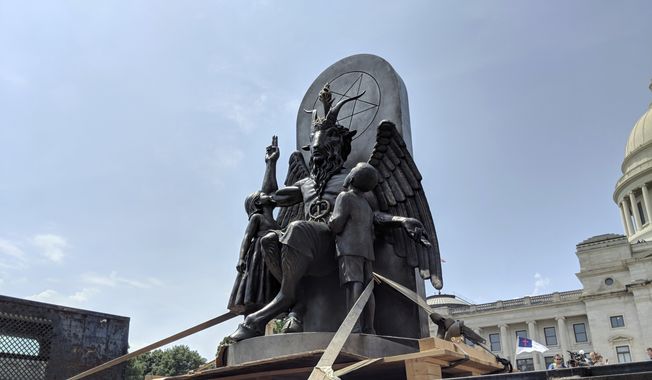 In this file photo, The Satanic Temple unveils its statue of Baphomet, a winged-goat creature, at a rally for the first amendment in Little Rock, Ark., Thursday, Aug. 16, 2018. (AP Photo/Hannah Grabenstein)  ** FILE **