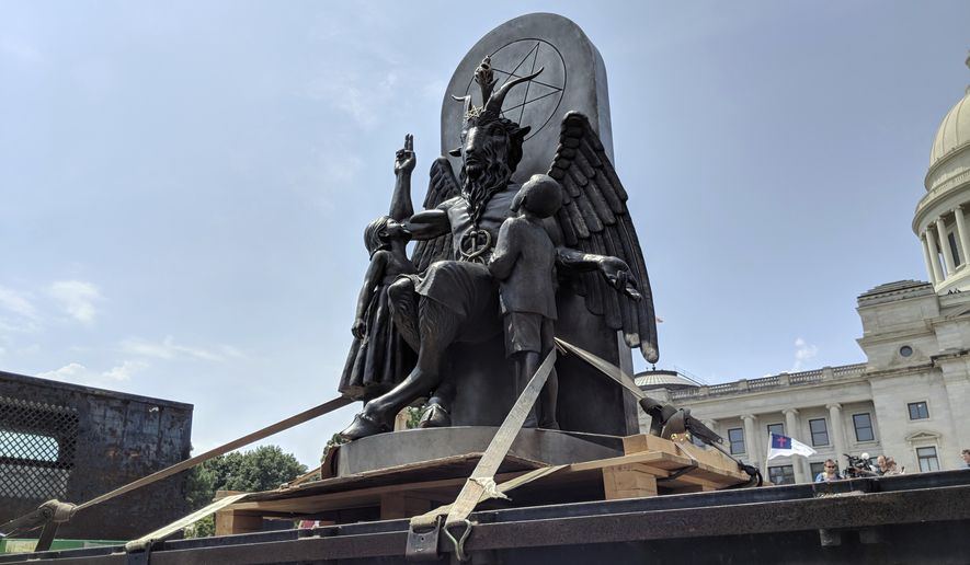 In this file photo, The Satanic Temple unveils its statue of Baphomet, a winged-goat creature, at a rally for the first amendment in Little Rock, Ark., Thursday, Aug. 16, 2018. (AP Photo/Hannah Grabenstein)  ** FILE **