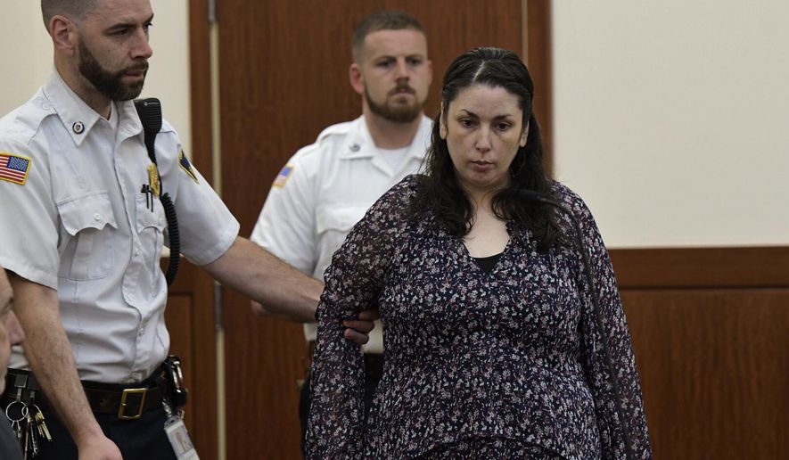 Erika Murray, charged in the deaths of two babies whose remains were found in her squalid home, is led into Superior Court, Thursday, June 20, 2019, in Worcester, Mass. (Rick Cinclair/Worcester Telegram & Gazette via AP)