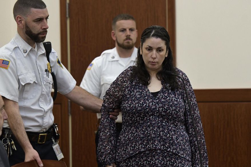 Erika Murray, charged in the deaths of two babies whose remains were found in her squalid home, is led into Superior Court, Thursday, June 20, 2019, in Worcester, Mass. (Rick Cinclair/Worcester Telegram & Gazette via AP)