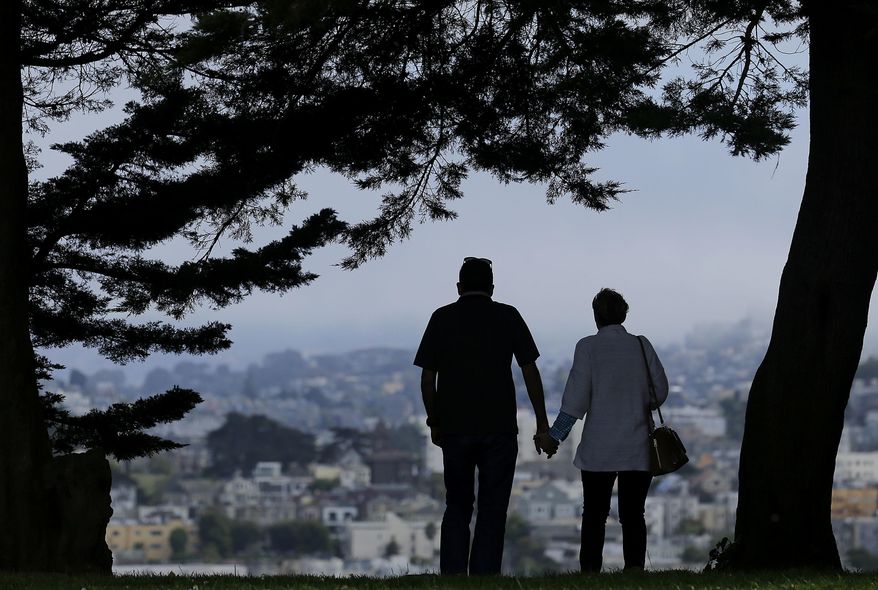 FILE - In this July 3, 2017 file photo, a man and woman walk under trees down a path at Alta Plaza Park in San Francisco. Data from the U.S. Census Bureau shows the median age in the U.S has increased by a year to 38.2 years from 2010 to 2018. The date released Thursday, June 20, 2019, comes as many baby boomers have been hitting the retirement age in recent years. (AP Photo/Jeff Chiu, File)