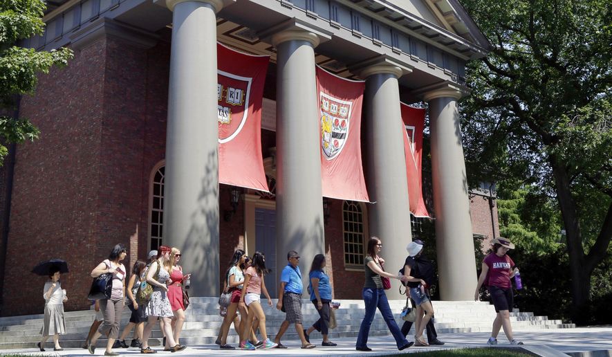 In this Aug. 30, 2012, file photo, a tour group walks through the campus of Harvard University in Cambridge, Mass. (AP Photo/Elise Amendola, File)