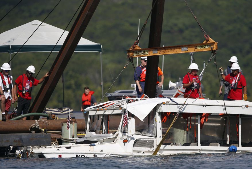 FILE - In this July 23, 2018, file photo, a duck boat that sank during a thunderstorm on July 19, 2018, killing 17 people on Table Rock Lake in Branson, Mo., is raised from the bottom of the lake. A federal grand jury on has indicted two more employees of a company that owns a duck boat that sank on a Missouri lake last summer, killing 17 people. The 47-count indictment was unsealed and made public Thursday, June 20, 2019 by the Springfield grand jury. (Nathan Papes/The Springfield News-Leader via AP, FIle)