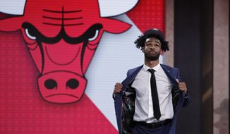 North Carolina&#39;s Coby White walks onstage after the Chicago Bulls selected him as the seventh overall in the NBA basketball draft Thursday, June 20, 2019, in New York. (AP Photo/Julio Cortez)