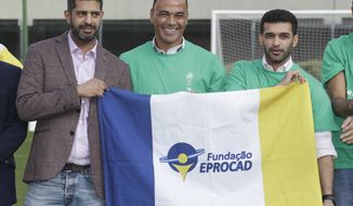 Former Brazilian soccer player Cafu, center, poses for a photo with Hassan Al Thawadi, left, Chairman of the FIFA World Cup Qatar 2022, and Nasser Al-Khater, right, deputy-secretary general of the Qatar 2022 organizing committee, during a event where Cafu was presented as an Ambassador for the World Cup 2022, in Sao Paulo, Brazil, Friday, June 21, 2019. (AP Photo/Andre Penner)