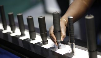 FILE- In this Jan. 19, 2016 file photo, gun silencers are on display at the Sig Sauer booth at the Shooting, Hunting and Outdoor Trade Show in Las Vegas. Gun silencers like the one used in a recent lethal shooting in Virginia Beach would be banned under legislation that U.S. Sen. Bob Menendez of New Jersey introduced Friday, June 21, 2019. (AP Photo/John Locher, File)