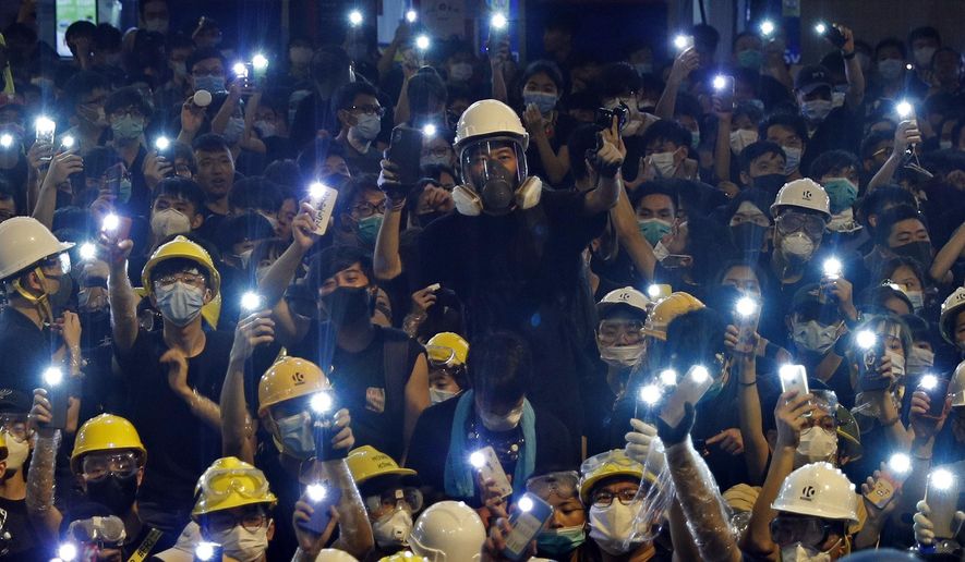 Protesters hold up the mobile phone lights in front of police headquarters in Hong Kong, Friday, June 21, 2019. More than 1,000 protesters blocked Hong Kong police headquarters into the evening Friday, while others took over major streets as the tumult over the city's future showed no signs of abating. (AP Photo/Vincent Yu)