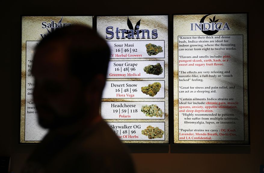 In this July 30, 2018, photo, screens display different strains of marijuana at a dispensary in Las Vegas. Nevada's marijuana enforcement chief says mistakes may have been made by temporary workers evaluating applications for dispensary licenses, but the process was fair. (AP Photo/John Locher)