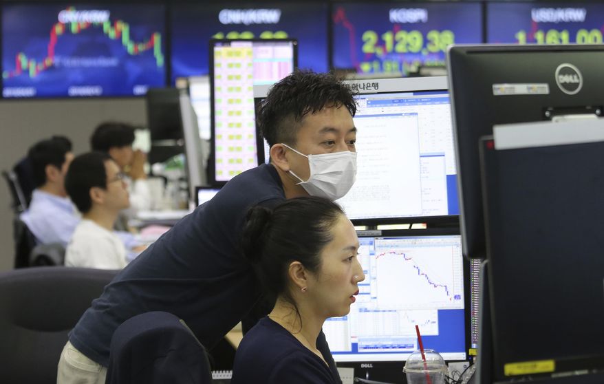 Currency traders watch monitors at the foreign exchange dealing room of the KEB Hana Bank headquarters in Seoul, South Korea, Friday, June 21, 2019. Shares retreated in Asia on Friday after a broad rally for stocks drove the S&P 500 index to an all-time high as weak manufacturing data from Japan helped dampen investor sentiment. (AP Photo/Ahn Young-joon)