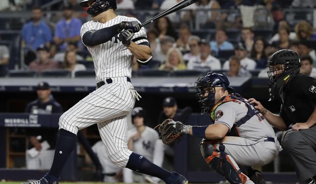 New York Yankees&#x27; Giancarlo Stanton follows through on a two-run single during the seventh inning of a baseball game as Houston Astros&#x27; catcher Max Stassi watches, Saturday, June 22, 2019, in New York. (AP Photo/Frank Franklin II)