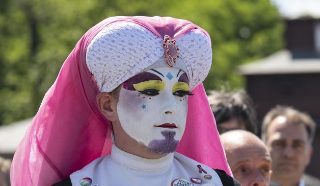 People attend a commemoration for prisoners assigned a pink triangle in the former Nazi concentration camp Buchenwald within the Christopher Street Day in Weimar, Germany, Sunday, June 23, 2019. There were 650 prisoners assigned a pink triangle in the Buchenwald concentration camp between 1937 and 1945. Many of them lost their lives. (AP Photo/Jens Meyer)