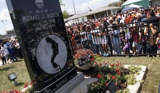 FILE - In this June 25, 2010 file photo, Michael Jackson fans gather around a monument that was unveiled in Gary, Ind., on the first anniversary of the pop icon&#39;s death. As the 10th anniversary of Jackson’s death approaches, experts say his music legacy is still going strong despite the documentary’s detailed abuse allegations. (AP Photo/John Smierciak, File)