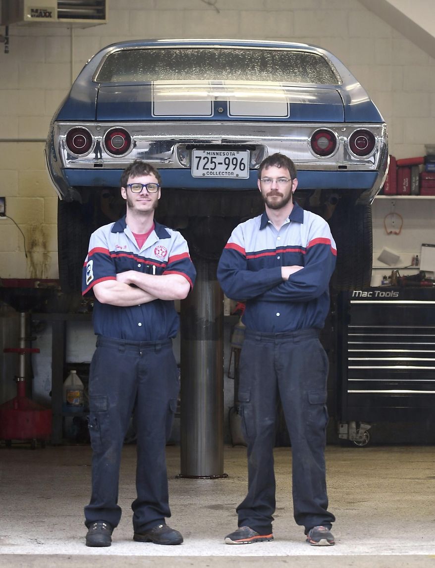 In this May 8, 2019 photo, brothers Tony, left, and Tyler Baumann stand in their shop at Old Town Garage in Mankato, Minn. The pair resurrected the historic building, which was originally built as a Texaco gas station. (Pat Christman/The Free Press via AP)
