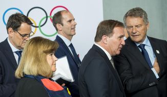 Swedish Prime Minister Stefan Lofven, right, reacts next to Gunilla Lindberg, IOC member of Sweden, left, during the first day of the 134th Session of the International Olympic Committee (IOC), at the SwissTech Convention Centre, in Lausanne, Switzerland, Monday, June 24, 2019. The host city of the 2026 Olympic Winter Games will be decided during the134th IOC Session. Stockholm-Are in Sweden and Milan-Cortina in Italy are the two candidate cities for the Olympic Winter Games 2026. (Jean-Christophe Bott/Keystone via AP)