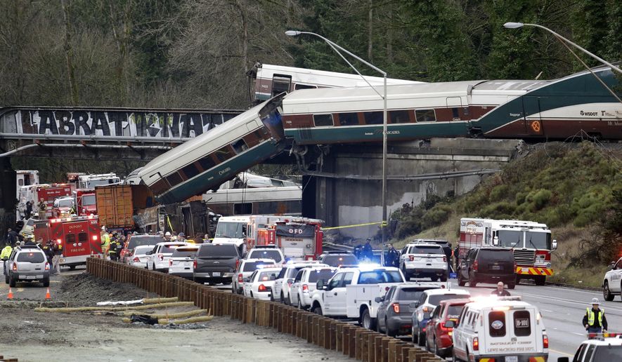 FILE - In this Dec. 18, 2017, file photo, cars from an Amtrak train lay spilled onto Interstate 5 below as some remain on the tracks above in DuPont, Wash. The National Transportation Safety Board has published its final report Monday, June 24, 2019, on a deadly Amtrak derailment in Washington state in 2017, with the agency&#x27;s vice chairman blasting what he described as a &amp;quot;Titanic-like complacency&amp;quot; among those charged with ensuring train operations are safe. The train was on its first paid passenger run on a new route from Tacoma to Portland, Oregon, when it plunged onto Interstate 5, killing three people and injuring dozens. (AP Photo/Elaine Thompson, file)