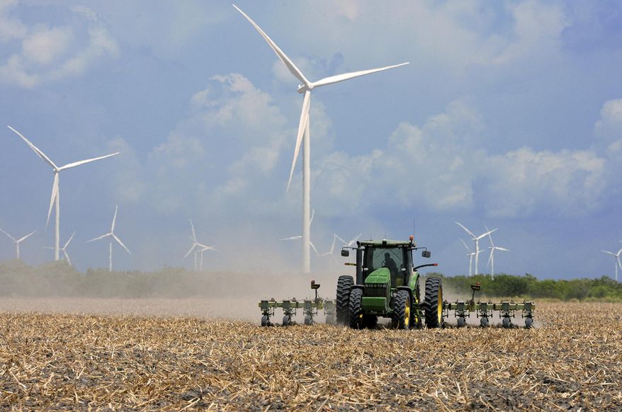 FILE - In this Aug. 17, 2015, file photo, a farmer plows his recently harvested field under wind turbines in the agricultural area north of Rio Hondo, Texas, near the New Mexico border. A new wind farm is coming to southeast New Mexico, and the project will bring turbines and transmission lines to key counties, the San Diego-based EDF Renewables recently announced. (Jason Hoekema/Valley Morning Star via AP, File)