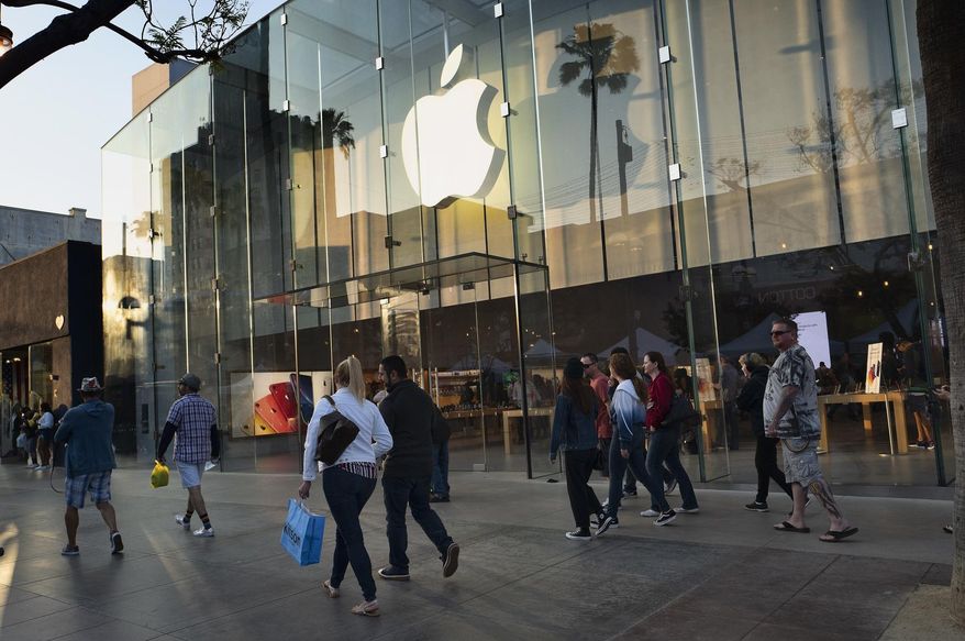In this Saturday June 15, 2019 photo pedestrians walk past an Apple store along the 3rd Street Promenade in Santa Monica, Calif. On Tuesday, June 25, the Conference Board releases its June index on U.S. consumer confidence. (AP Photo/Richard Vogel)
