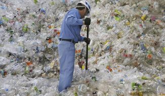In this June 18, 2019, photo, a plastic recycling company worker sorts out plastic bottles collected for processing at Tokyo Petbottle Recycle Co., Ltd, in Tokyo. Japan has a plastic problem. Single bananas here are sometimes wrapped in plastic. So are individual pieces of vegetables, fruit, pastries, pens and cosmetics. Plastic-wrapped plastic spoons come with every ice cream cup. But as world leaders descend on Osaka for the two-day G20 Summit that starts Friday, June 28, Japan has ambitions to become a world leader in reducing plastic waste. (AP Photo/Koji Sasahara)