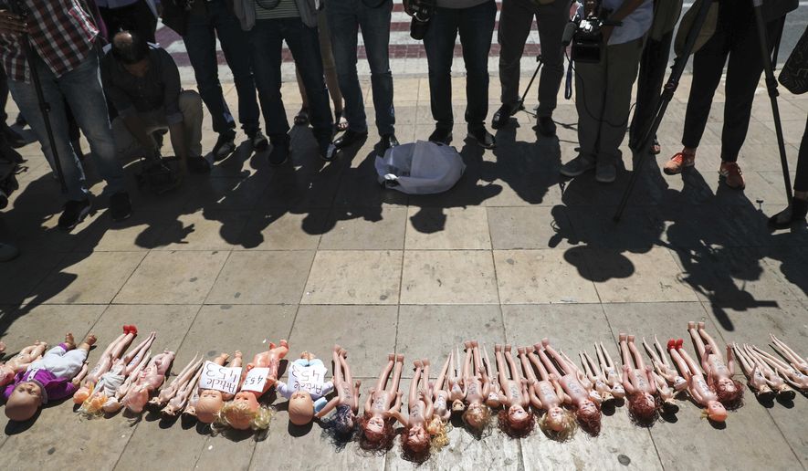 Dolls are laid out in front of Rabat's parliament by pro-choice protesters, to pressure legislatures to pass a law to protect women from unsafe and clandestine abortions, Morocco, Tuesday, June 25, 2019. The dolls symbolically exhibits the fate of undesired Moroccan children, whose mothers do not have the means or the capacities to care for them. (AP Photo/Mosa'ab Elshamy)