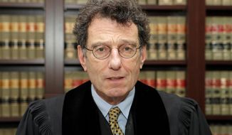 FILE – In this Jan. 11, 2018, file photo, U.S. District Judge Dan Polster poses for a portrait in his office in Cleveland. Polster is holding a hearing Tuesday, June 25, 2019,  in Cleveland on a plan pitched by lawyers for local governments on distributing money to nearly 25,000 municipal and county governments. The plan would take effect if companies that make and distribute the powerful prescription painkillers agree to one or more legal settlements. (AP Photo/Tony Dejak, File)