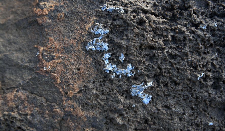 In this photo provided by MARE and taken on Friday, June 21, 2019, 'plasticrusts' are see on the surface of rocks in Madeira island. Researchers say they may have identified a new kind of plastic pollution in the sea, and they're calling it "plasticrust." Scientists working on Madeira, a volcanic Portuguese island off northwest Africa, have found small patches of what look like melted plastic encrusted on rocks along the shoreline. (Ignacio Gestoso Garcia/MARE via AP)
