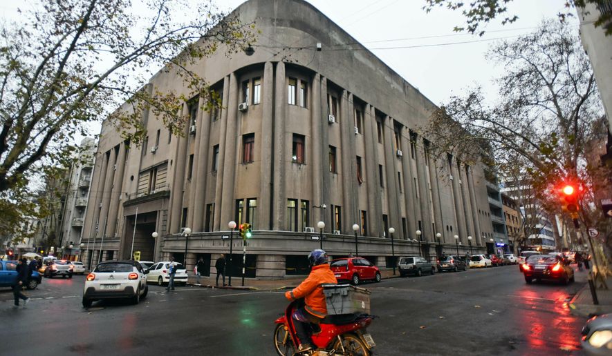 Commuters pass by the "Carcel Central de Montevideo" in Montevideo, Uruguay, Monday, June 24, 2019. Top Italian organized crime boss, Rocco Morabito, escaped before dawn Monday from this prison where he was awaiting extradition to Italy, according to Uruguay’s interior ministry. (AP Photo/Matilde Campodonico)