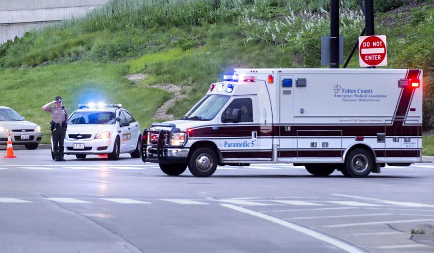 In this Tuesday, June 25, 2019 photo, an Illinois State Police trooper salutes as the ambulance bearing the body of Fulton County Sheriff's Deputy Troy Chisum, passes enroute to OSF Saint Francis Medical Center in Peoria, Ill. Authorities say the sheriff's deputy died after being shot while responding to a call in Avon, Ill., where a suspect was barricaded in a home. (David Zalaznik/Journal Star via AP)