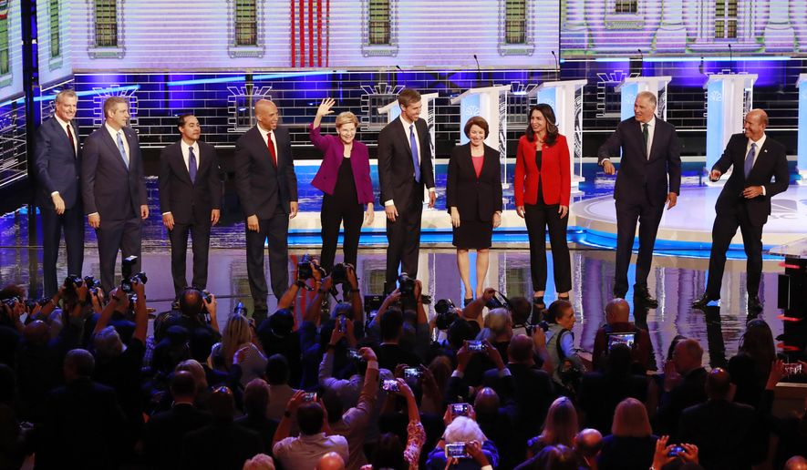 From left, New York City Mayor Bill de Blasio, Rep. Tim Ryan, D-Ohio, former Housing and Urban Development Secretary Julian Castro, Sen. Cory Booker, D-N.J., Sen. Elizabeth Warren, D-Mass., former Texas Rep. Beto O’Rourke, Sen. Amy Klobuchar, D-Minn., Rep. Tulsi Gabbard, D-Hawaii, Washington Gov. Jay Inslee, and former Maryland Rep. John Delaney pose for a photo on stage before the start of a Democratic primary debate hosted by NBC News at the Adrienne Arsht Center for the Performing Arts, Wednesday, June 26, 2019, in Miami. (AP Photo/Wilfredo Lee)