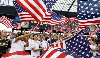 Fans of the U.S. team wave flags as the players are introduced for a CONCACAF Gold Cup soccer match against Panama in Kansas City, Kan., Wednesday, June 26, 2019. (AP Photo/Colin E. Braley)