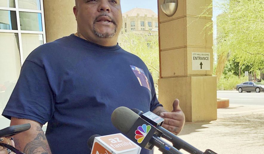 Roland Harris of Phoenix talks about his son, Jacob Harris, who was shot and killed in January after the armed robbery of a fast food restaurant, outside Phoenix City Hall Wednesday, June 26, 2019. He is demanding to see body camera video that he believes exists of the encounter with Phoenix police. The families of several people shot by Phoenix police have spoken out after the recent release of a video that shows officers aiming guns and obscenities at a black family whose daughter took a doll from a store. (AP Photo/Anita Snow)
