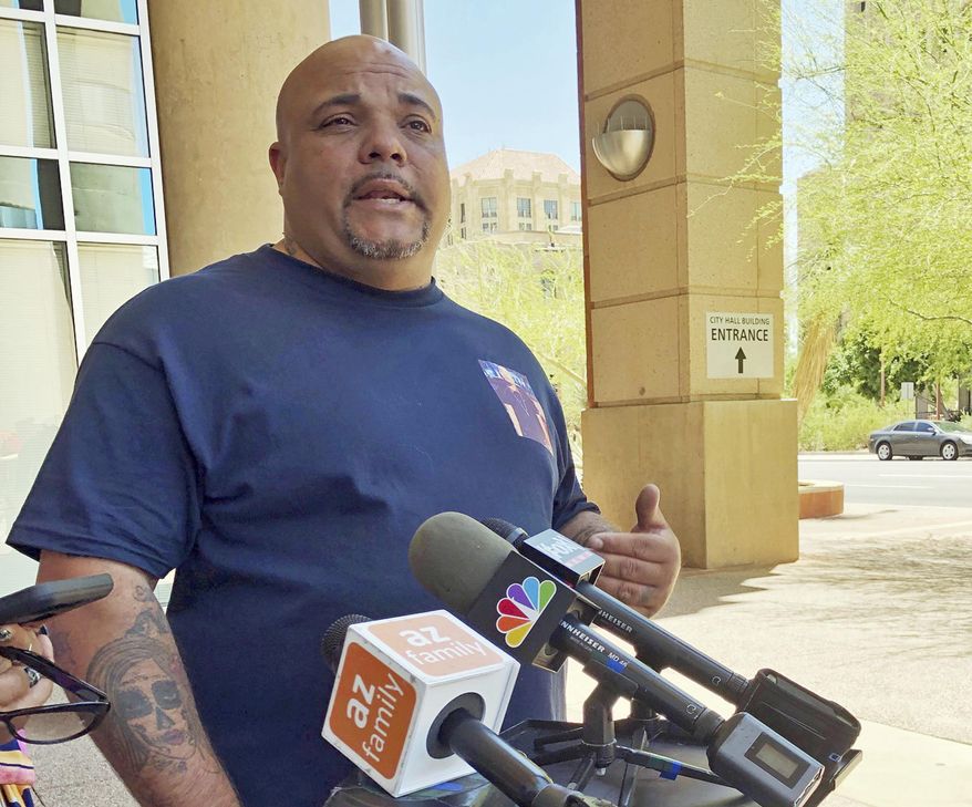 Roland Harris of Phoenix talks about his son, Jacob Harris, who was shot and killed in January after the armed robbery of a fast food restaurant, outside Phoenix City Hall Wednesday, June 26, 2019. He is demanding to see body camera video that he believes exists of the encounter with Phoenix police. The families of several people shot by Phoenix police have spoken out after the recent release of a video that shows officers aiming guns and obscenities at a black family whose daughter took a doll from a store. (AP Photo/Anita Snow)