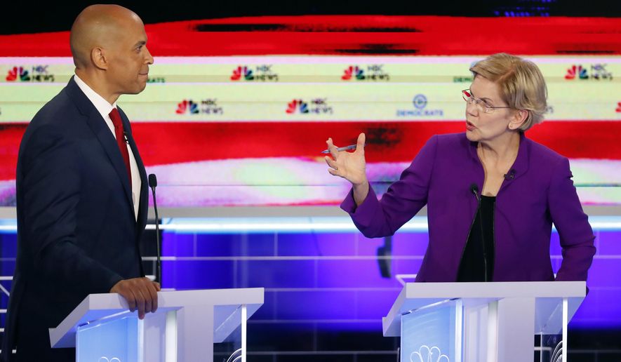 Democratic presidential candidate Sen. Elizabeth Warren, D-Mass., gestures towards New Jersey Sen. Cory Booker, during a Democratic primary debate hosted by NBC News at the Adrienne Arsht Center for the Performing Arts, Wednesday, June 26, 2019, in Miami. (AP Photo/Wilfredo Lee)