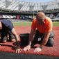 Workers prepare the pitch during an unveiling of the London Stadium in London, Thursday, June 27, 2019. Major League Baseball (MLB) will make its mark its European debut with the New York Yankees versus Boston Red Sox game at London Stadium this weekend. (AP Photo/Frank Augstein) **FILE**