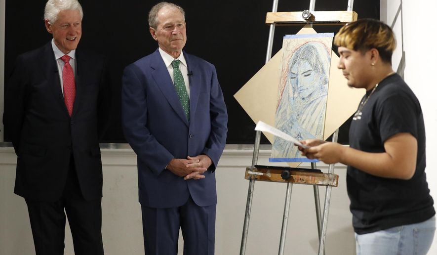 Former Presidents Bill Clinton, left, and George W. Bush, center, listen as Sylvester, right, recites a performance piece at the Meadows School of the Arts in Dallas, Thursday, June 27, 2019. (AP Photo/Tony Gutierrez)