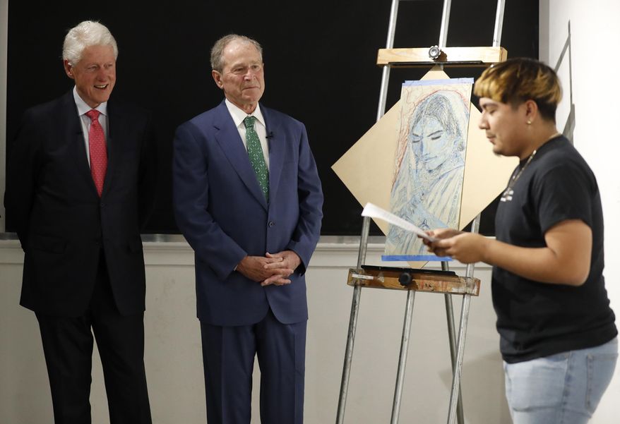 Former Presidents Bill Clinton, left, and George W. Bush, center, listen as Sylvester, right, recites a performance piece at the Meadows School of the Arts in Dallas, Thursday, June 27, 2019. (AP Photo/Tony Gutierrez)