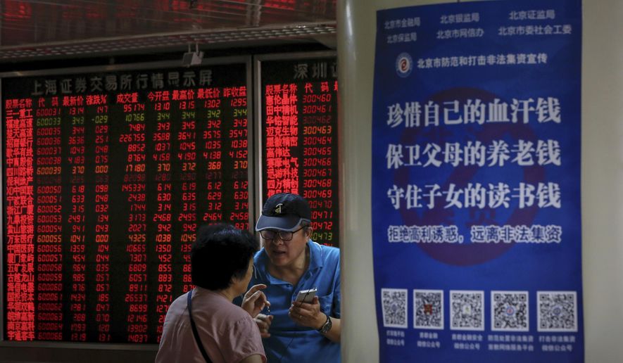 Chinese investors chat each other as they monitor stock prices at the brokerage house in Beijing, Thursday, June 27, 2019. Asian stocks advanced Thursday ahead of a meeting between U.S. President Donald Trump and Chinese leader Xi Jinping at the G-20 summit in Japan this week. (AP Photo/Andy Wong)