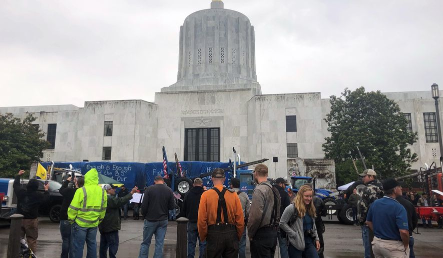 Protesters converge outside the Oregon state Capitol in Salem, Ore. on Thursday, June 27, 2019. Truckers, loggers and farmers say they support the eleven Republican senators who walked out over a week ago to avoid a vote on climate legislation. (AP Photo/Sarah Zimmerman)